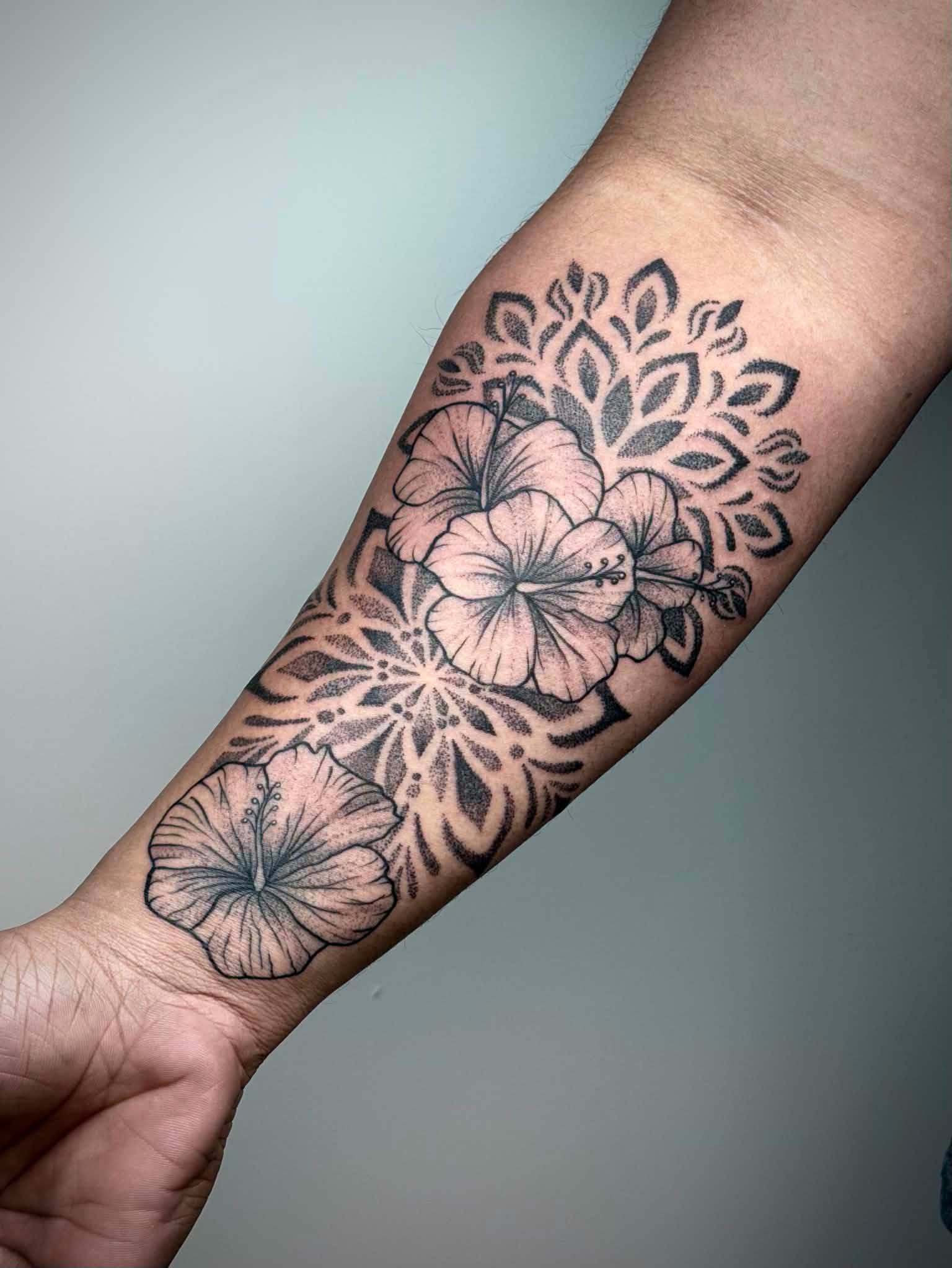 Hibiscus and mandala tattoo on forearm